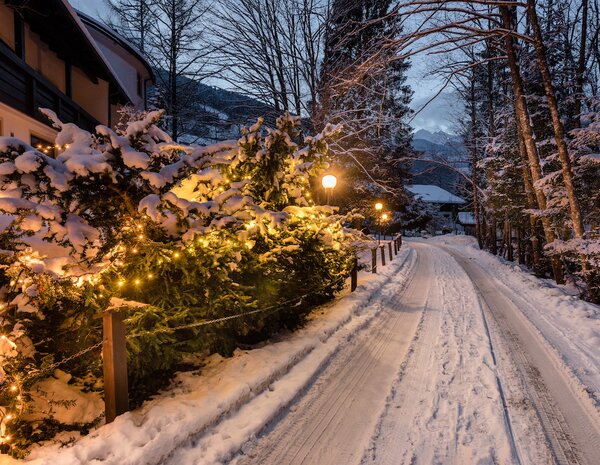 Beleuchteter Spazierweg direkt vom Hotel weg in die Winterlandschaft