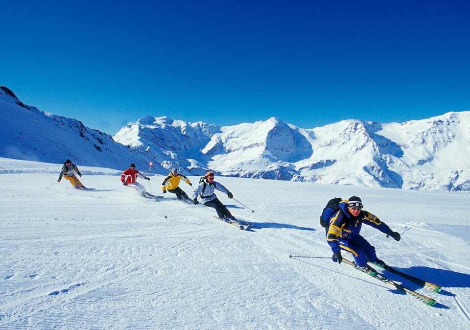 Skifahrer-Runde fahren hintereinander auf der präparierten Piste