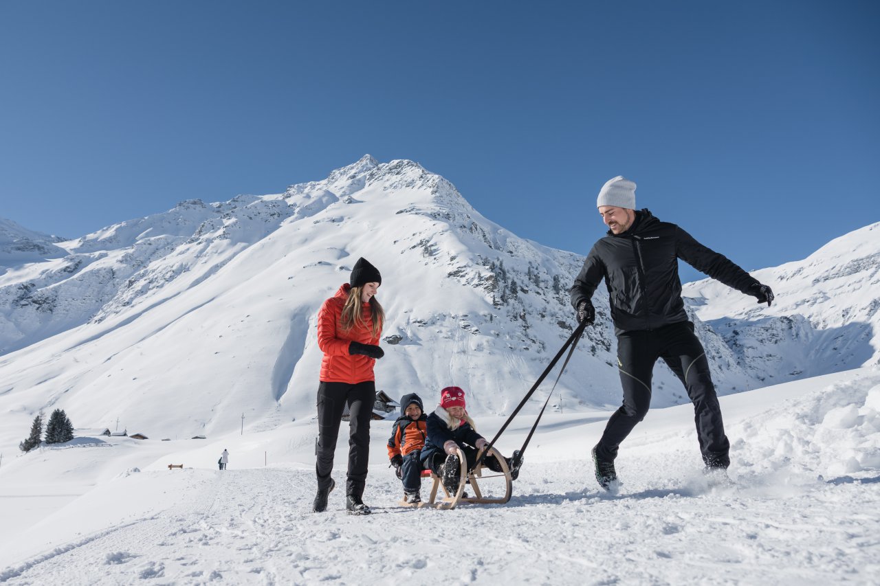 Familie beim gemeinsamen Rodeln