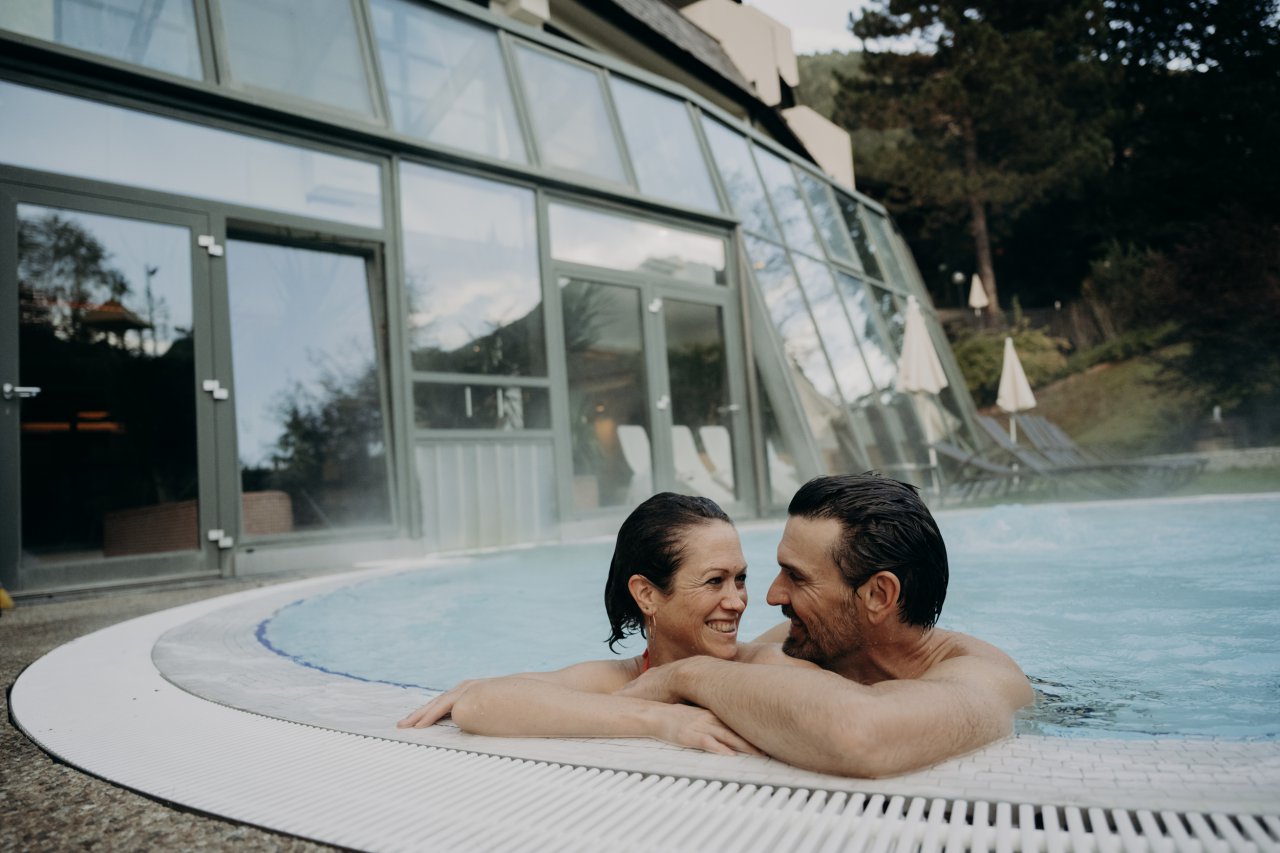 Heated outdoor pool at Hotel Sonngastein with views of the Gastein mountains