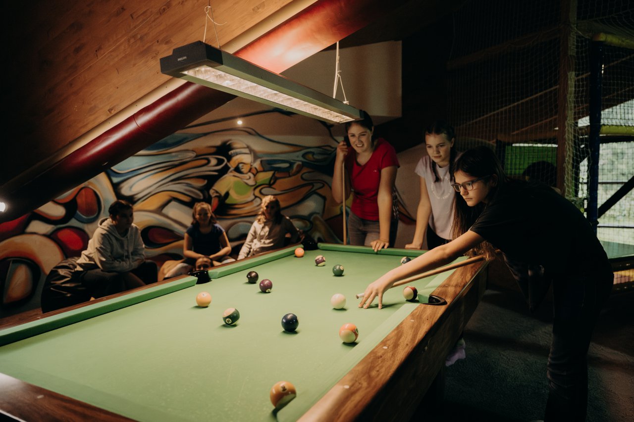Teenager beim gemeinsamen Billardspielen im Hotel Sonngastein