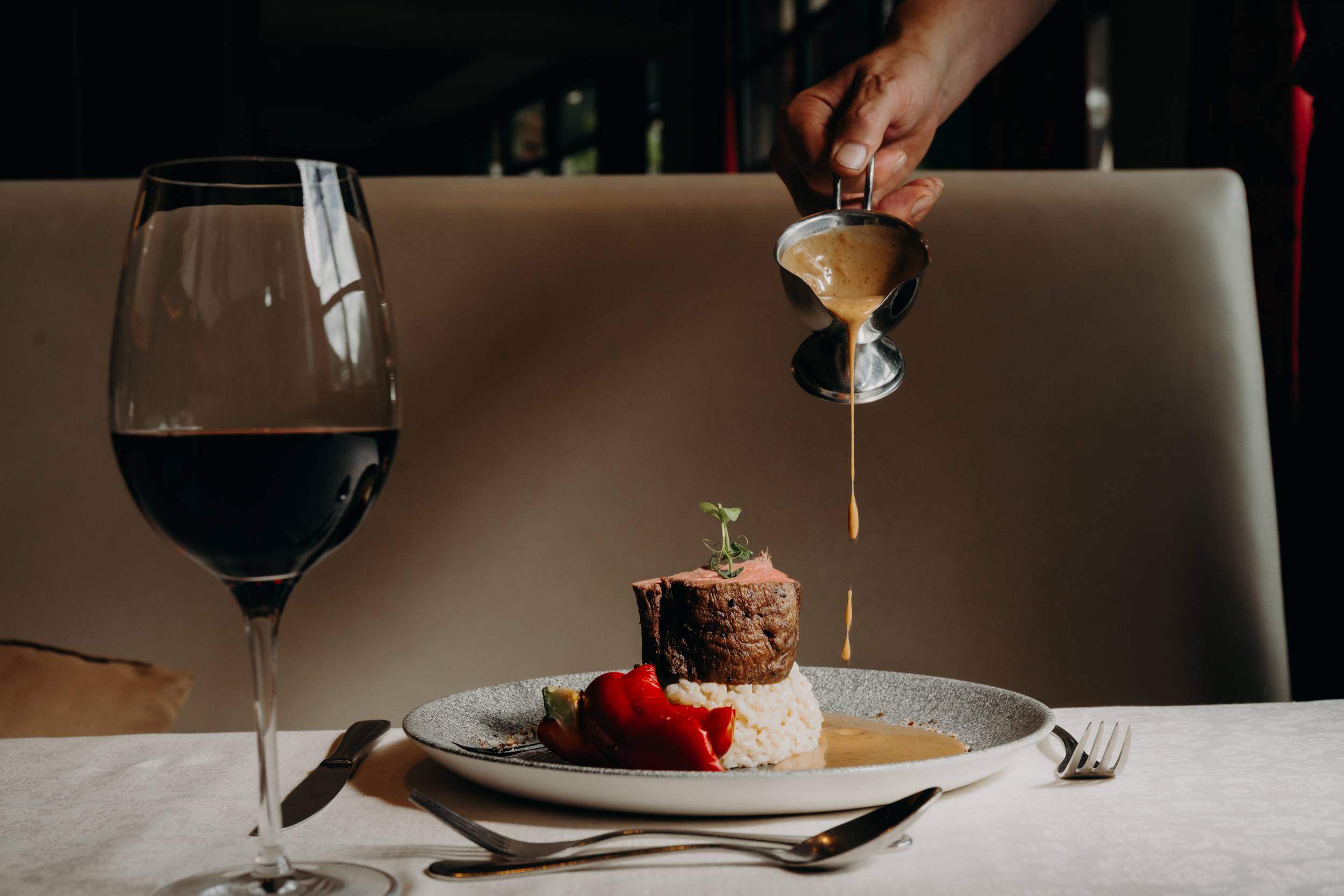 Rinderfilet mit Reis und Sauce im Restaurant, serviert mit Rotwein – Fine Dining Genuss