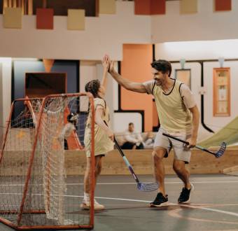 Vater und Tochter geben sich ein High Five beim Hockey spielen