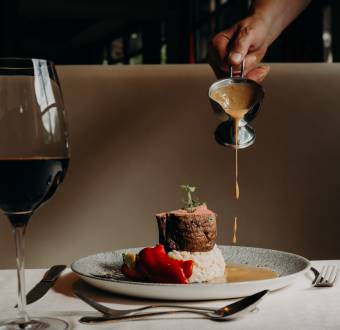 Rinderfilet mit Reis und Sauce im Restaurant, serviert mit Rotwein – Fine Dining Genuss