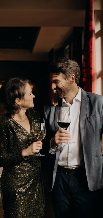 Mann und Frau haben sich schick angezogen und trinken einen guten Wein im Restaurant