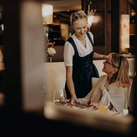 Kellnerin serviert einer Familie das Essen