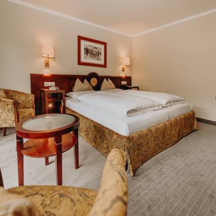 Geräumiges Doppelzimmer mit Sitzecke, Couchtisch und komfortablem Doppelbett im Hotel in Bad Gastein