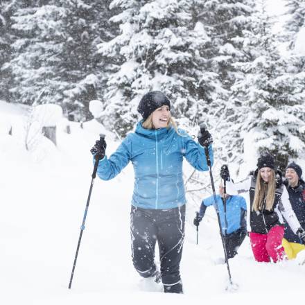 Schneeschuhwanderung durch verschneite Winterlandschaft in den Bergen mit geführter Gruppe