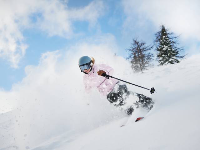 Skifahrerin fährt durch den Tiefschnee