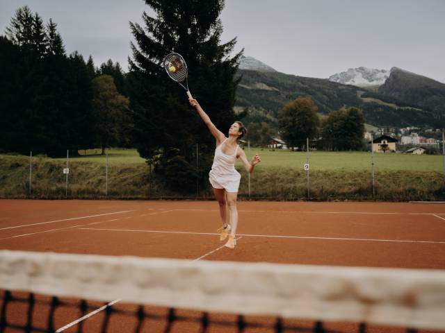 Eine Frau schlägt einen Ball zurück beim Tennis