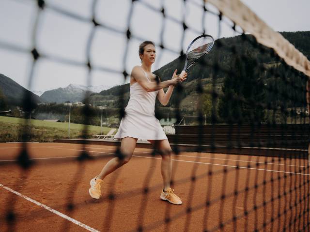 Eine Frau beim Tennisspielen im Hotel Sonngastein
