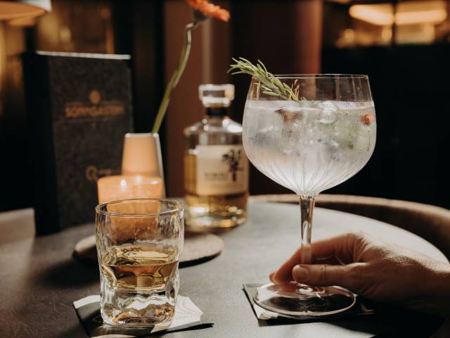 Eine Frau hält einen Cocktail in der Hotelbar