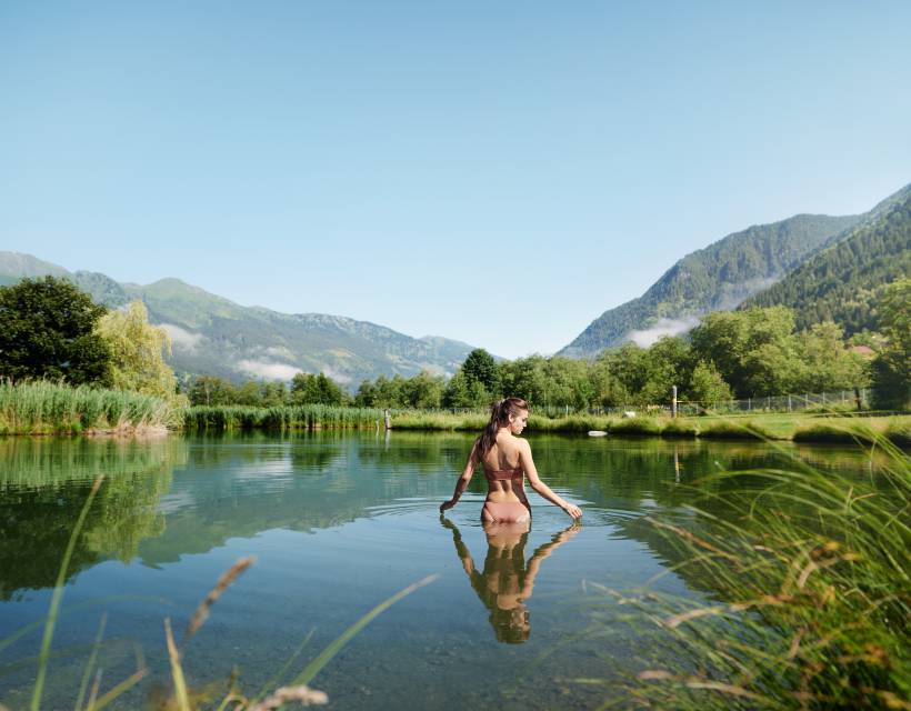 Eine Frau läuft in den Badesee