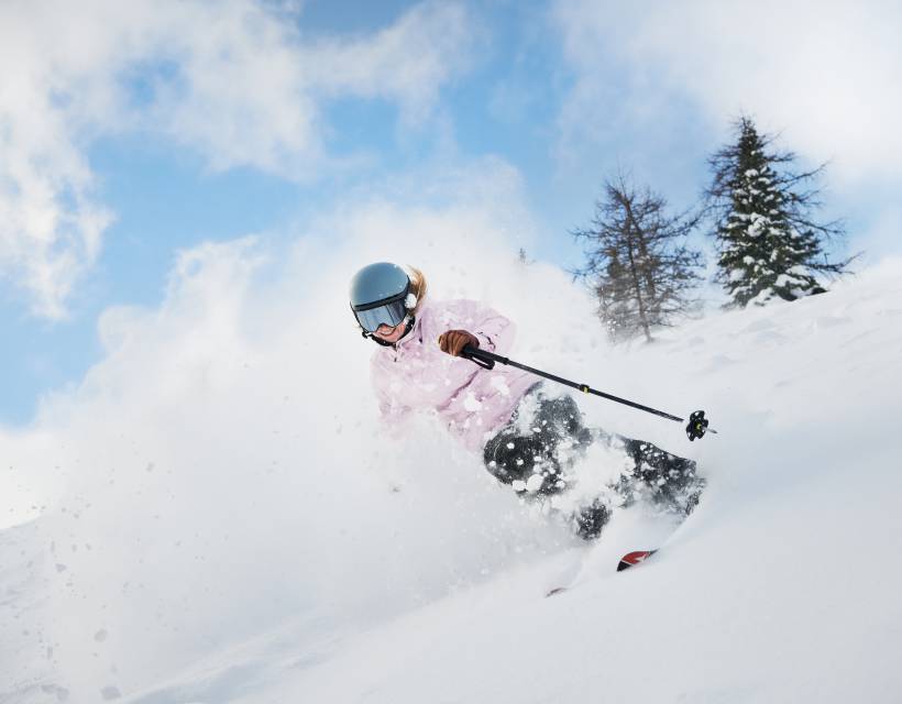 Skifahrerin fährt durch den Tiefschnee