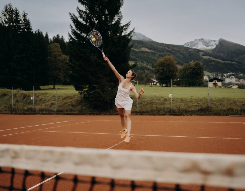 Eine Frau schlägt einen Ball zurück beim Tennis