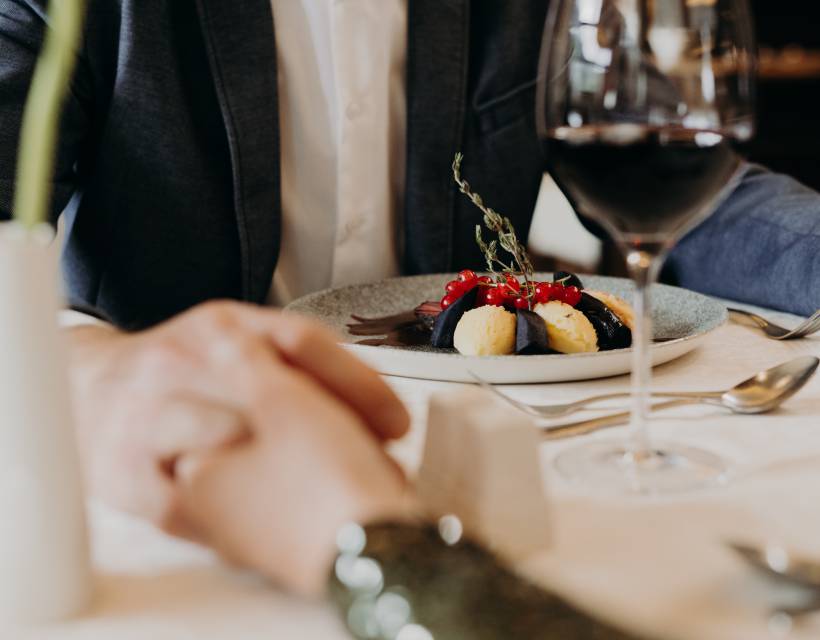 Paar bei Abendessen im Restaurant hält die Hände 