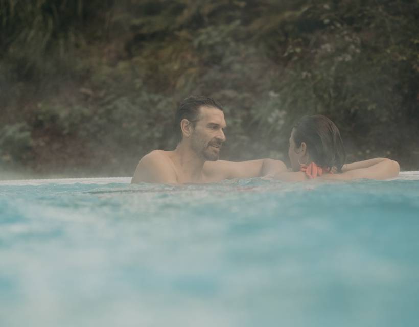 Ein Paar unterhält sich im Aussenpool des Hotel Sonngastein