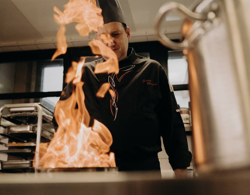 Koch flambiert in der Küche