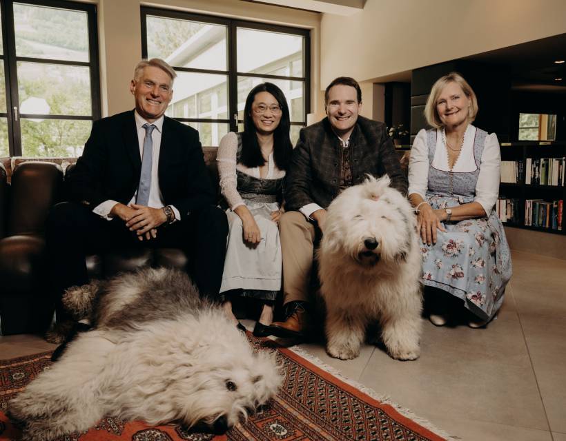 amily portrait with two dogs in an elegant hotel lounge – welcoming host team in a warm atmosphere
