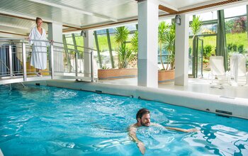 Pärchen beim Schwimmen im Indoor-Pool