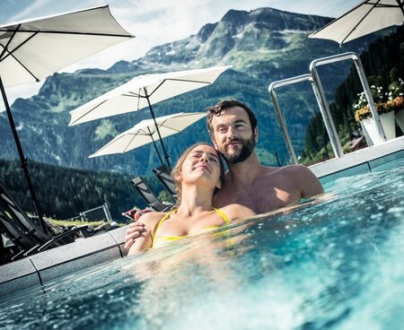 Pärchen relaxt im Außenpool in der Alpentherme