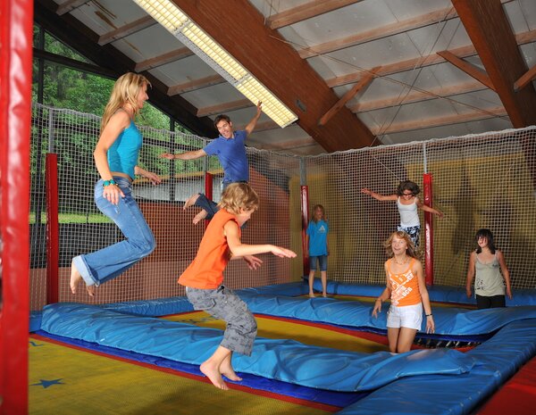 Familie und Kinder springen auf der 3-Feld-Trampolinanlage