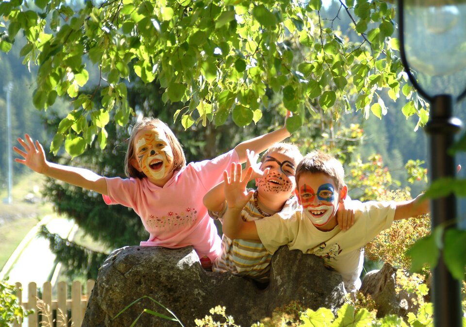 Geschminkte Kinder spielen im Freien