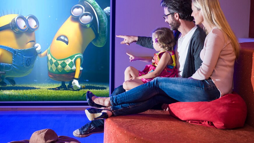 Familie schaut Minions im Hotelkino