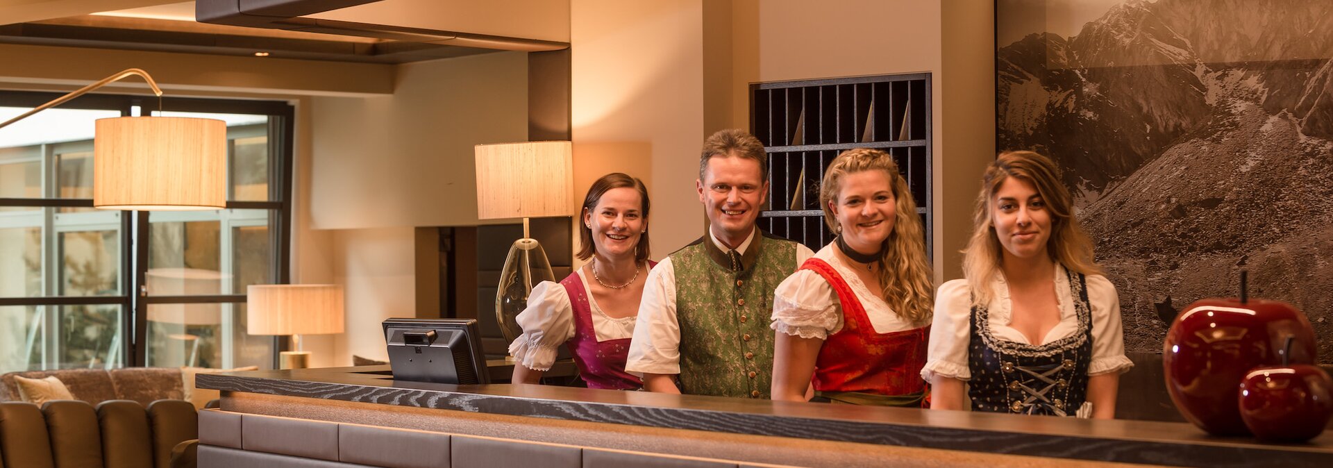 Rezeptions-Team in fescher Tracht in der Hotellobby