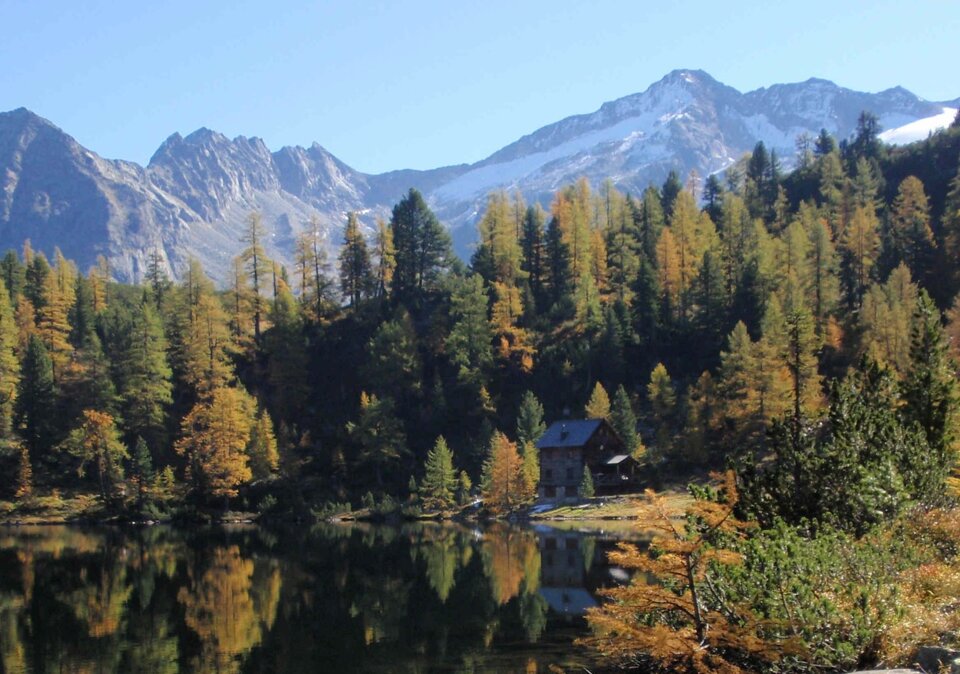 Badesee in spätsommerlicher Berglandschaft