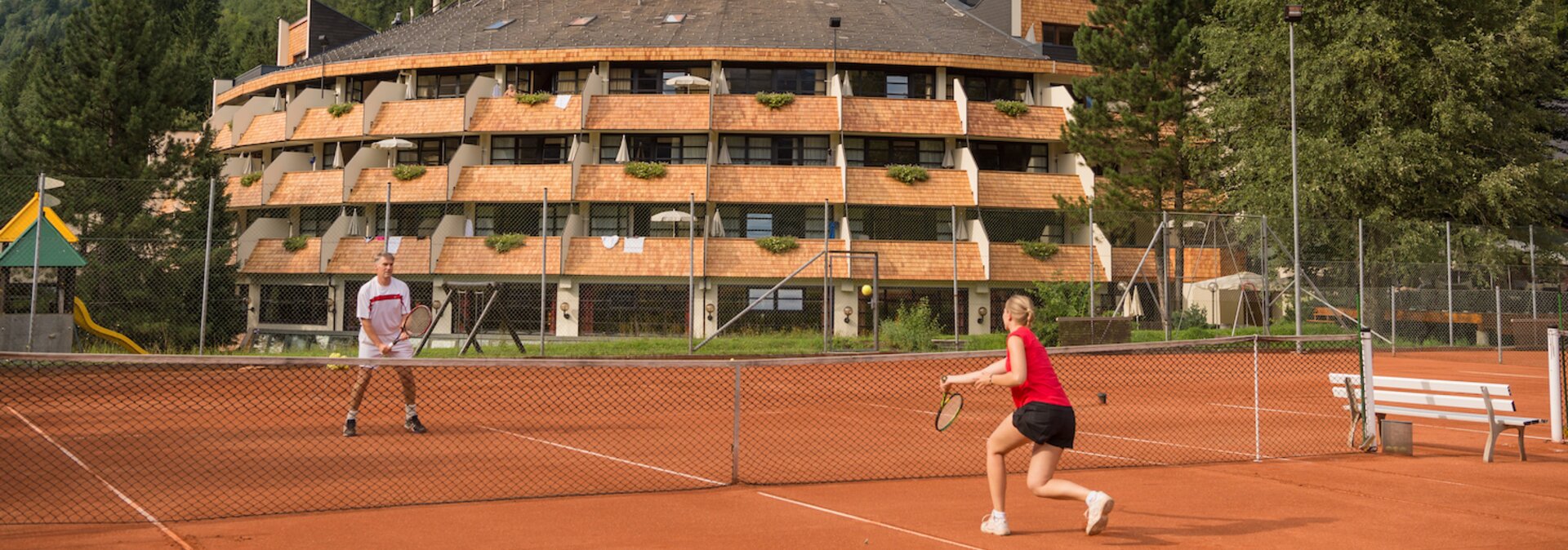 Tennisspieler am Sandcourt vor dem Hotel