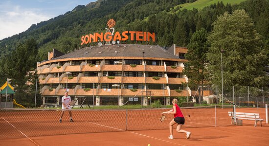 Tennisspieler am Sandcourt vor dem Hotel