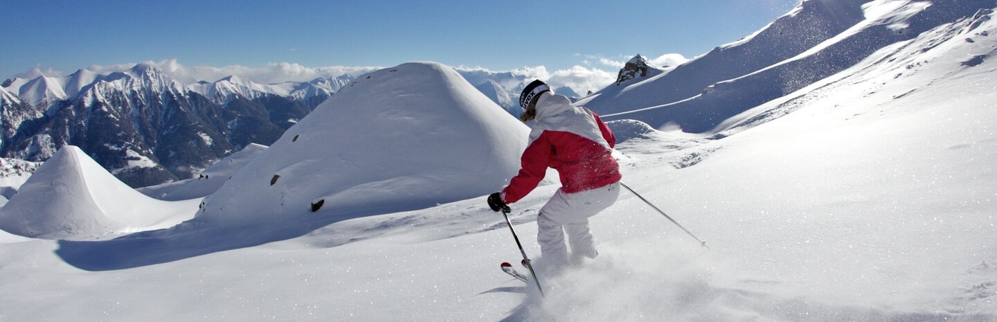 Skifahrer fährt im Tiefschnee die Pisten hinunter