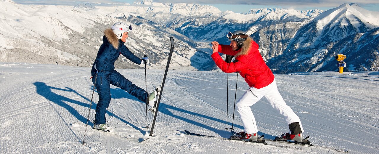 Pärchen mit Ski vor Bergpanorama